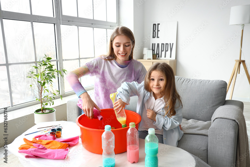 Little girl with her sister making tie-dye t-shirt at home