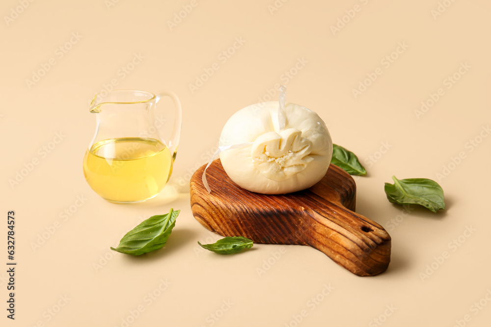 Wooden board of tasty Burrata cheese with basil and oil on yellow background