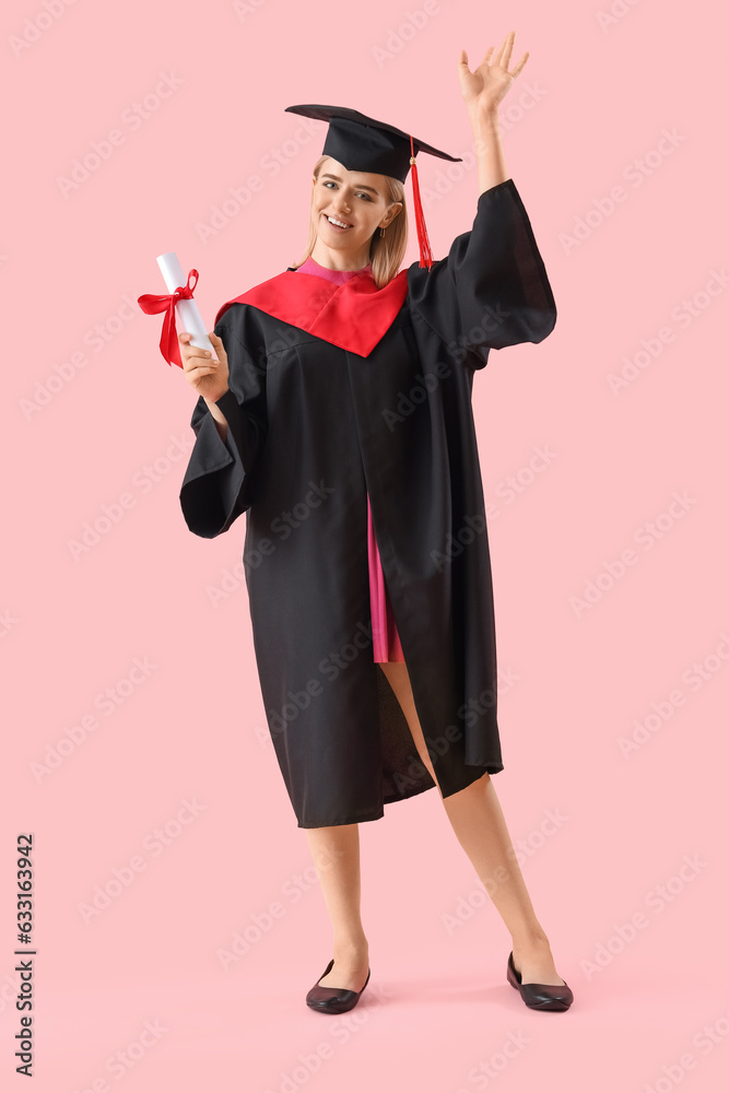 Happy female graduate student with diploma on pink background