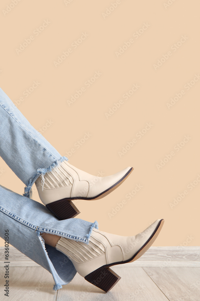 Female legs in stylish shoes near color wall, closeup