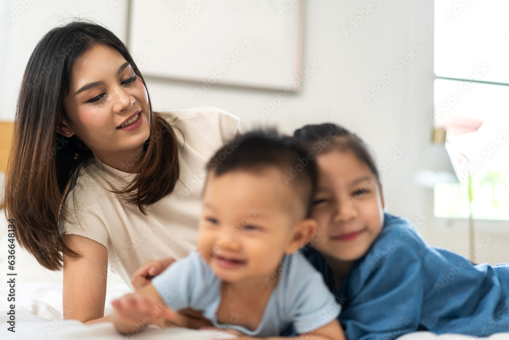 Portrait of enjoy happy love family asian mother playing with adorable little asian baby and sister 