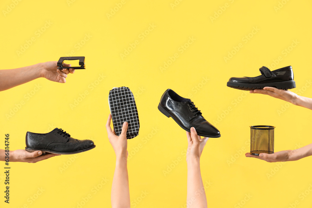 Female hands with different stationery and school shoes on yellow background