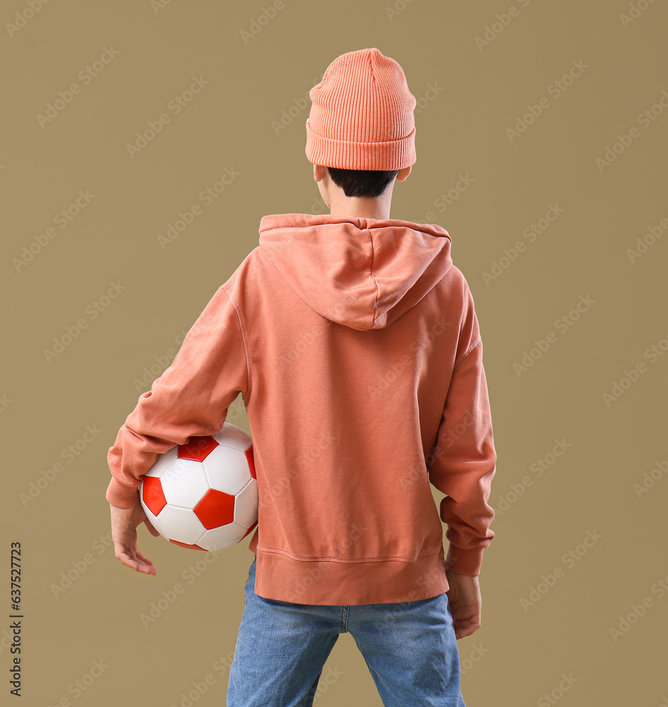 Little boy with soccer ball on color background, back view