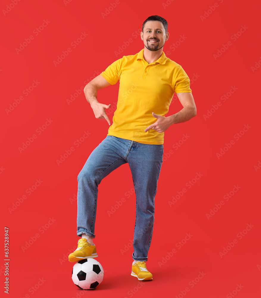 Happy man with soccer ball on red background