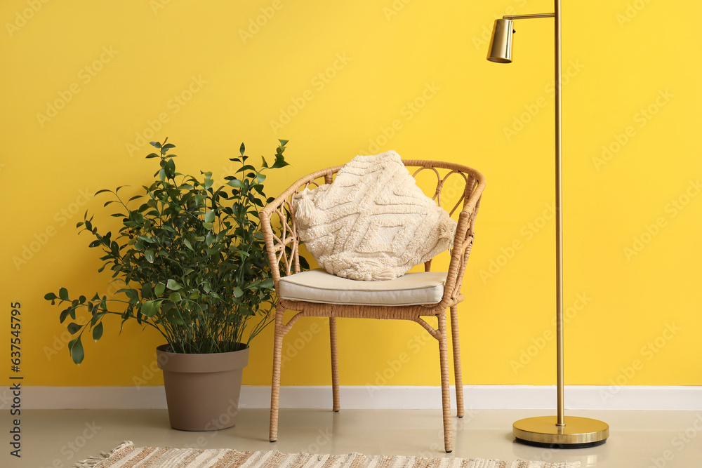 Standard lamp and armchair near yellow wall