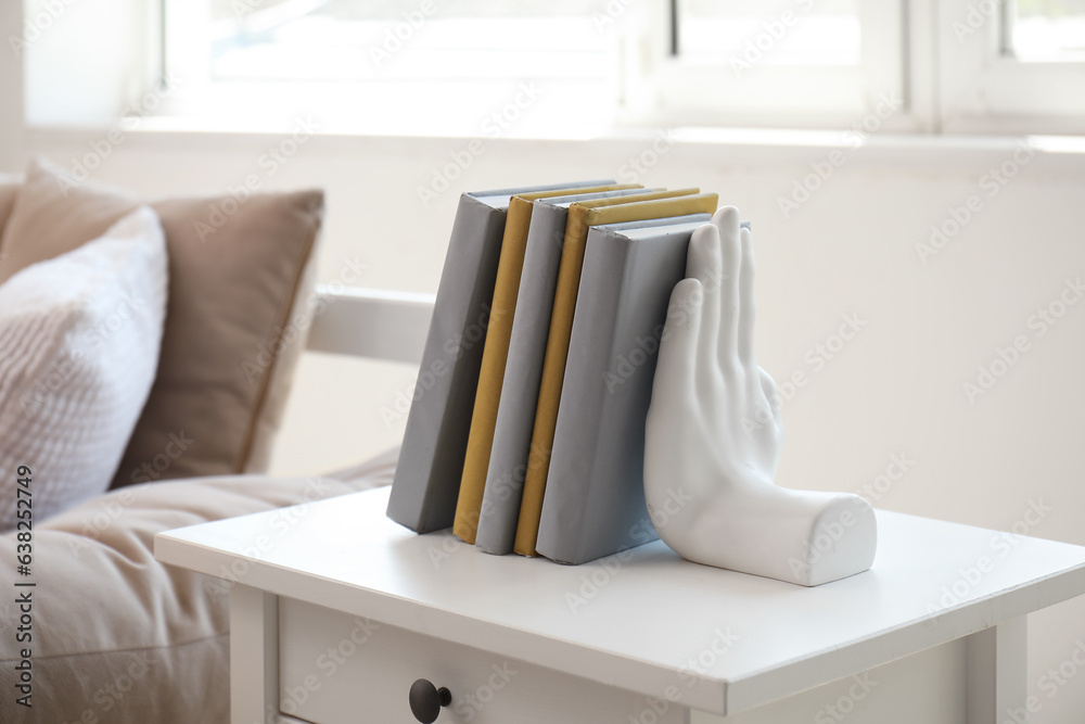 Stylish holder for books on table in room