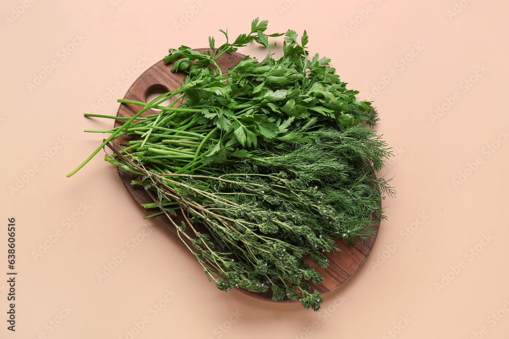 Wooden board with different fresh herbs on color background