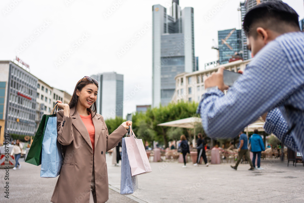 Asian young man and woman shopping goods outdoors in department store. 