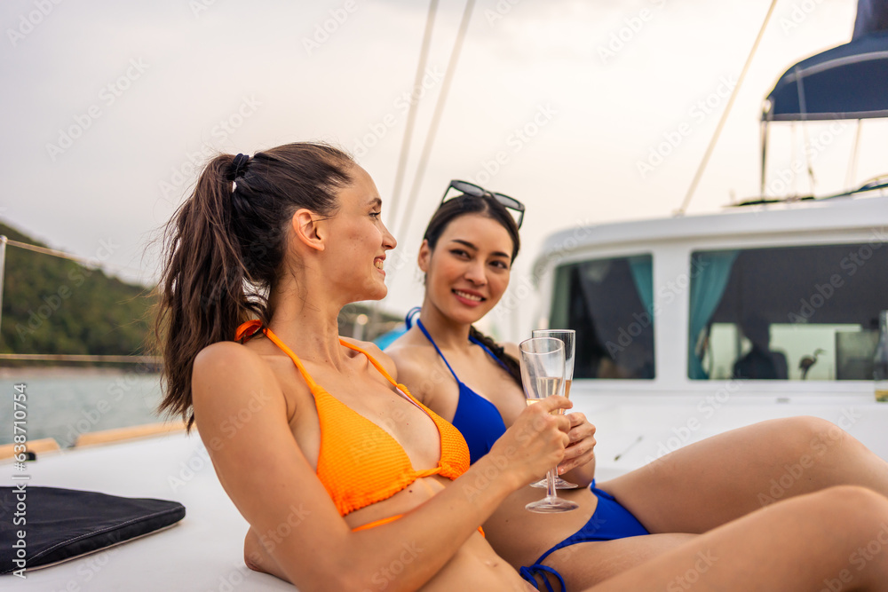 Two young women enjoy luxurious yachting experience, sipping champagne. 