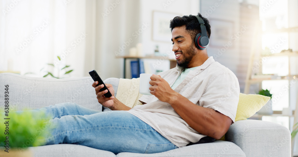Coffee, phone and happy man on sofa with headphones for social media, video streaming service and ne