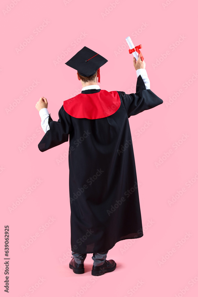 Male graduate student with diploma on pink background, back view