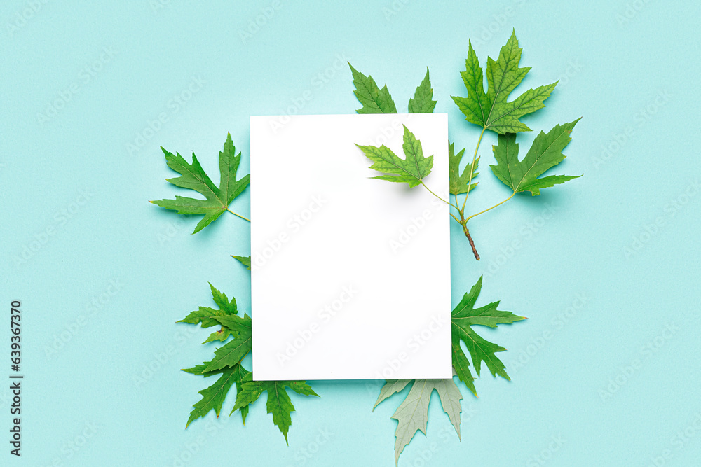 Composition with blank paper sheet and maple leaves on color background