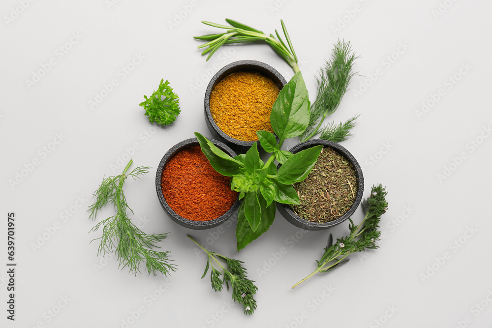 Composition with spices and fresh herbs on light background