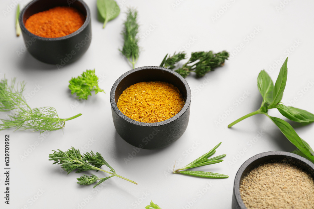 Composition with fresh herbs and different spices on light background, closeup