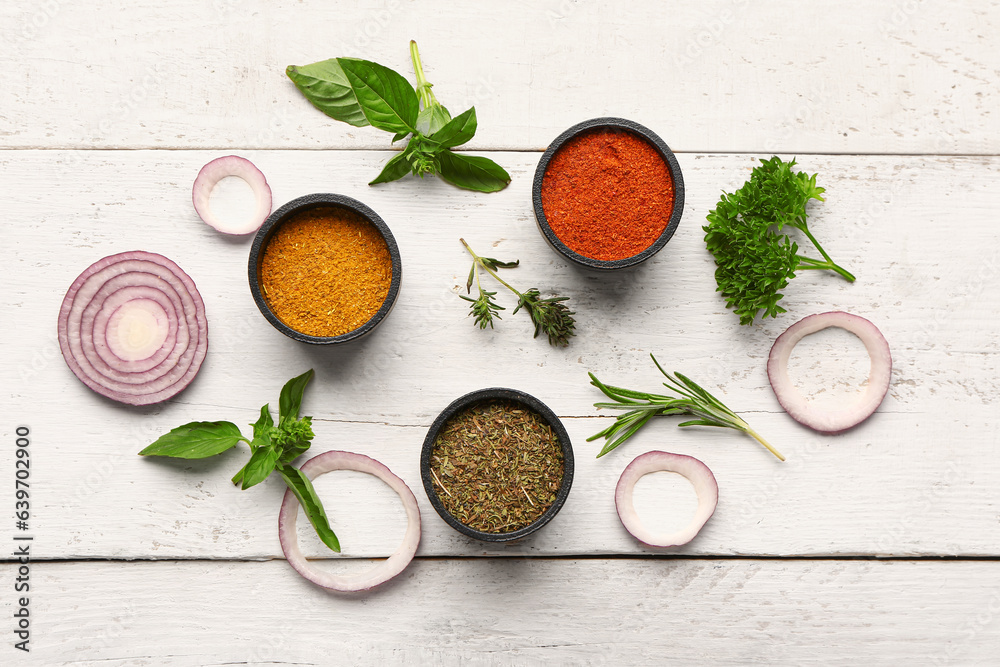 Composition with fresh spices and herbs on light wooden background