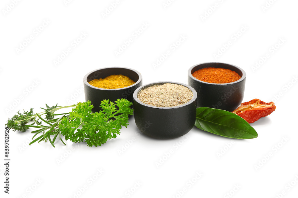 Bowls with spices and fresh herbs isolated on white background