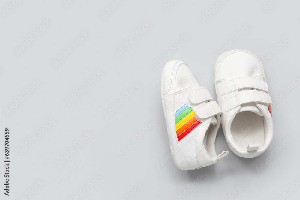 Stylish baby shoes on grey background