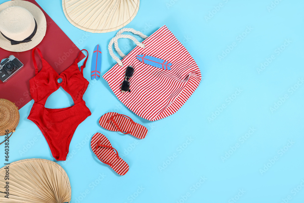 Different beach accessories on blue background. Travel concept
