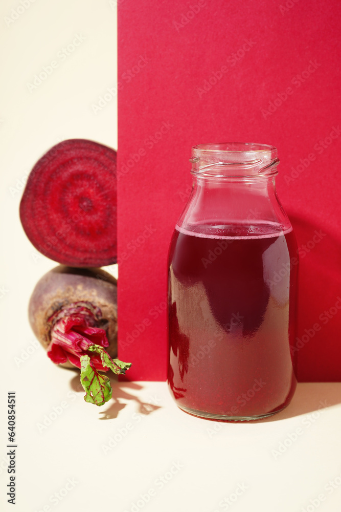 Bottle of healthy beet juice on colorful background