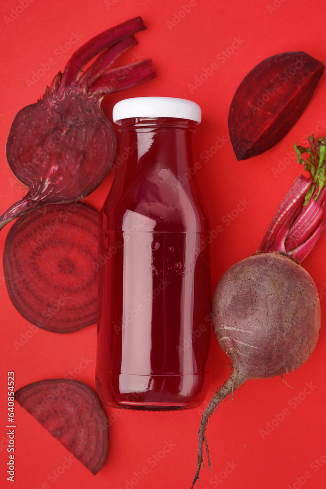Bottle of healthy beet juice on red background