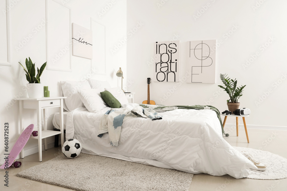 Interior of childrens bedroom with guitar, skateboard and soccer ball