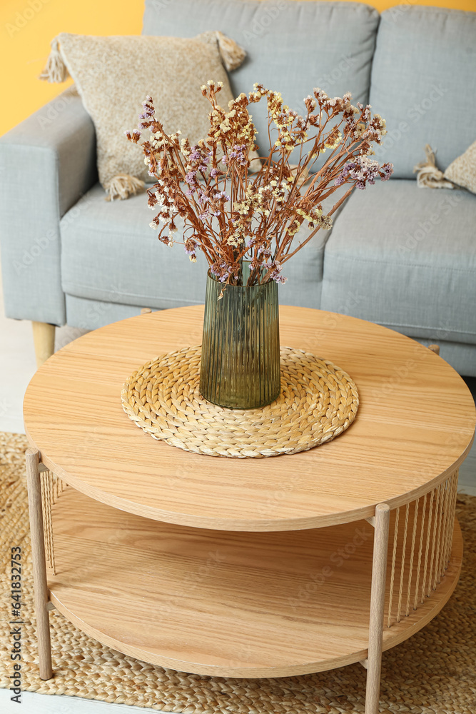 Vase of dried flowers on coffee table near couch