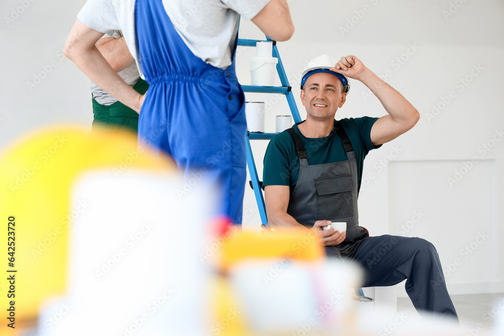 Team of male builders during coffee break in room