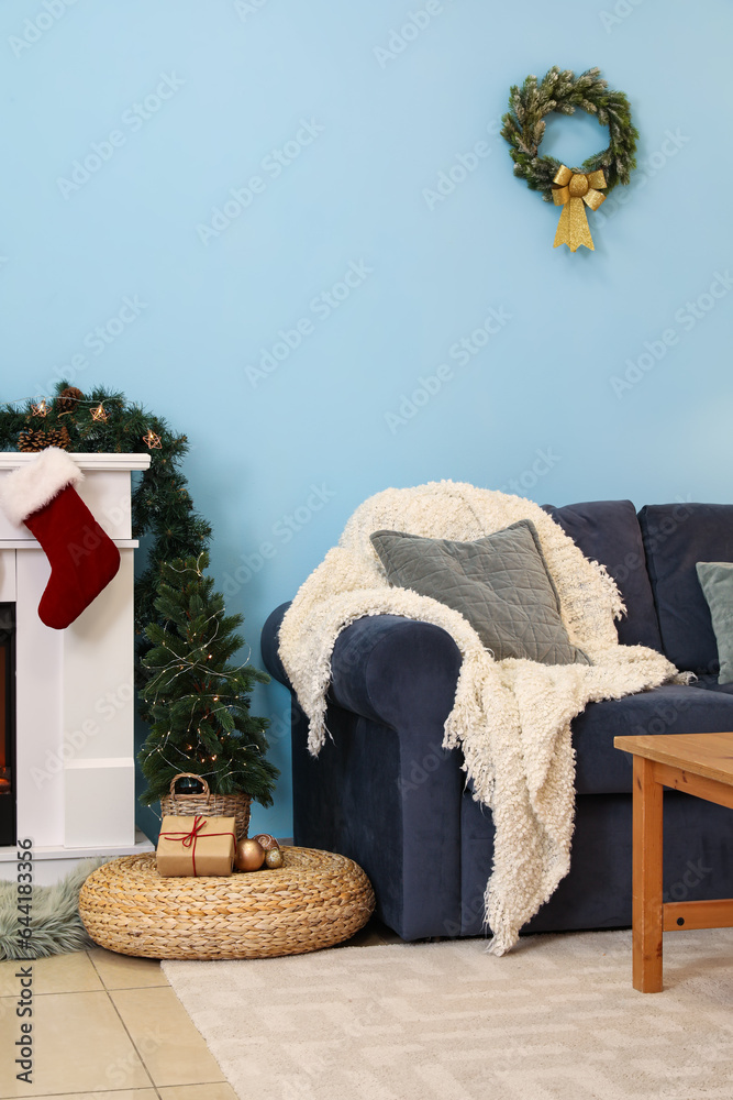 Interior of living room with fireplace, sofa, coffee table and Christmas decorations