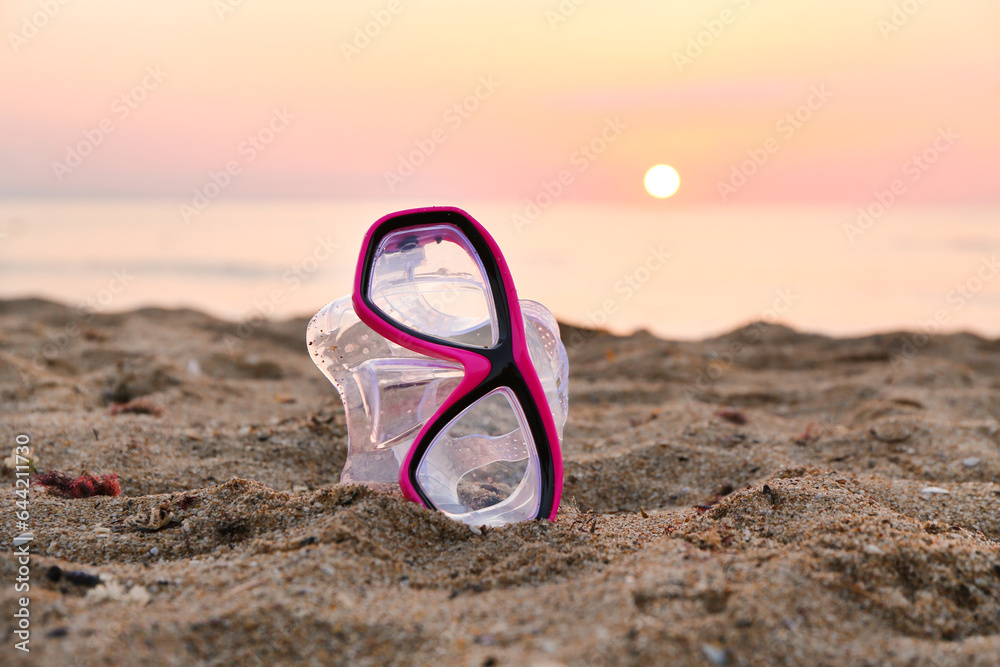New swimming mask on sand near sea