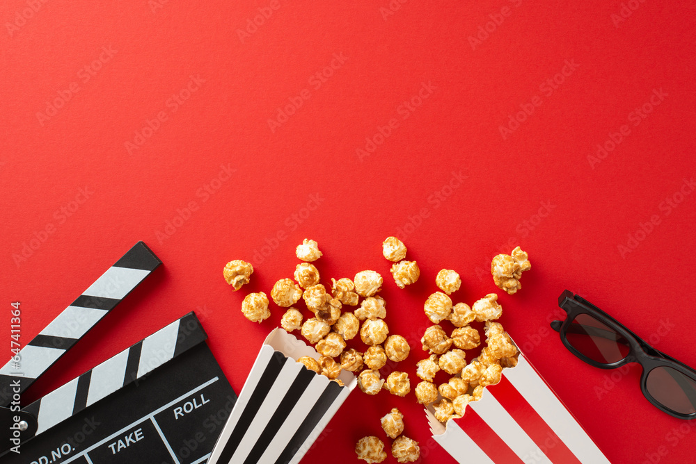 Gather Round for Movie Time: Top-down view of popcorn, 3D glasses, and a clapperboard on red backgr
