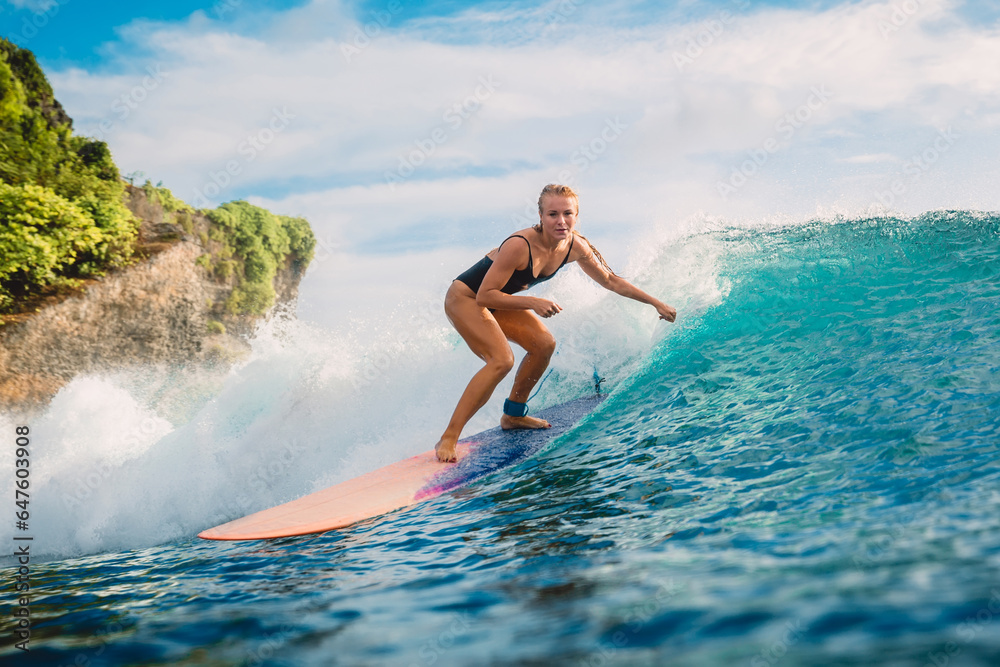 Surf girl ride on longboard. Attractive surfer woman and blue ocean wave