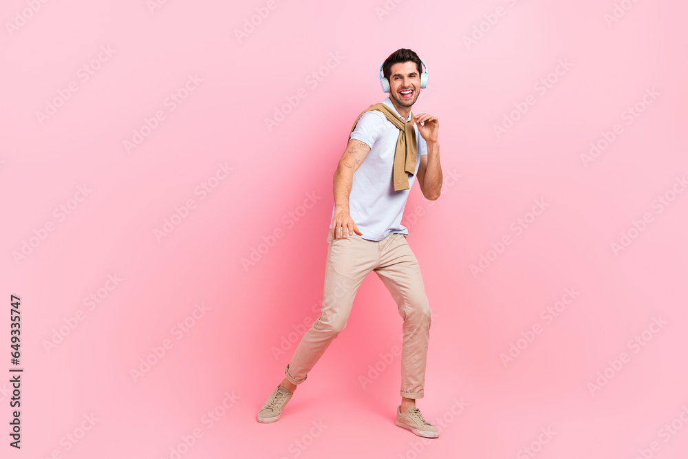 Full body photo of overjoyed nice young person listen music headphones dancing isolated on pink color background