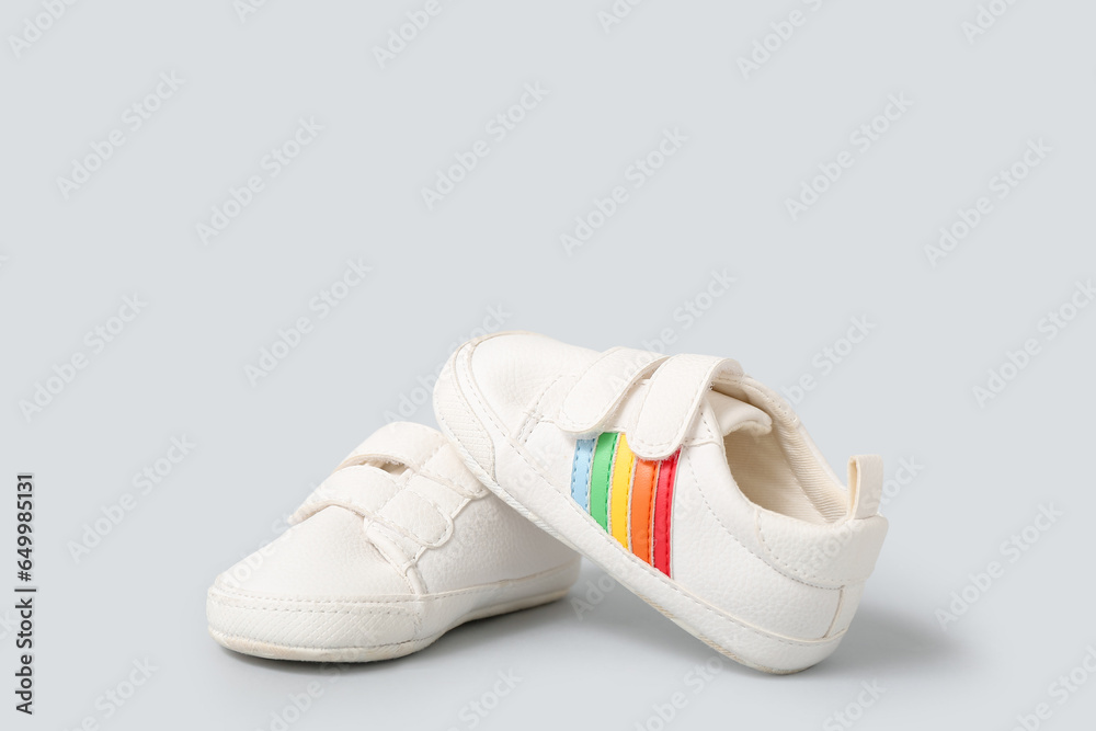 Pair of stylish baby shoes on grey background