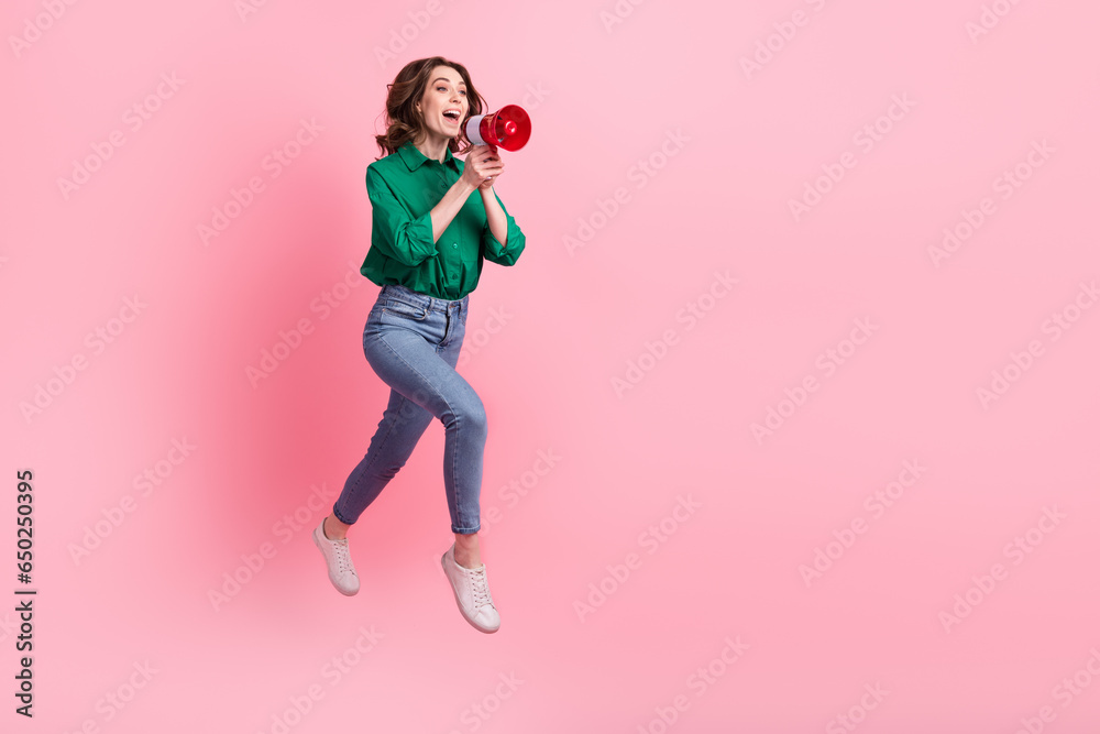 Full size profile photo of excited crazy girl jump run communicate loudspeaker empty space isolated on pink color background