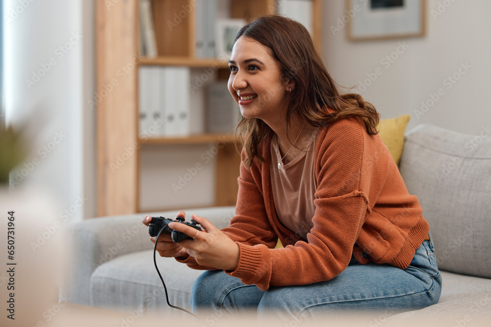 Happy woman, sofa and playing video games in relax or free time in living room for entertainment at home. Female person smile with controller for console or online gaming on lounge couch in house