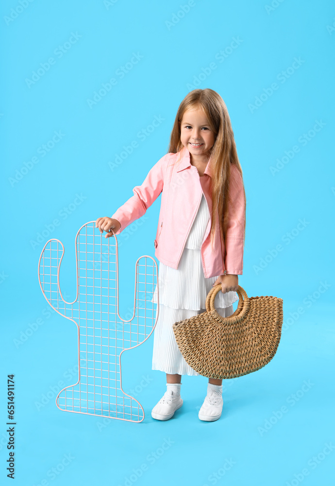 Cute little girl with pin board on blue background