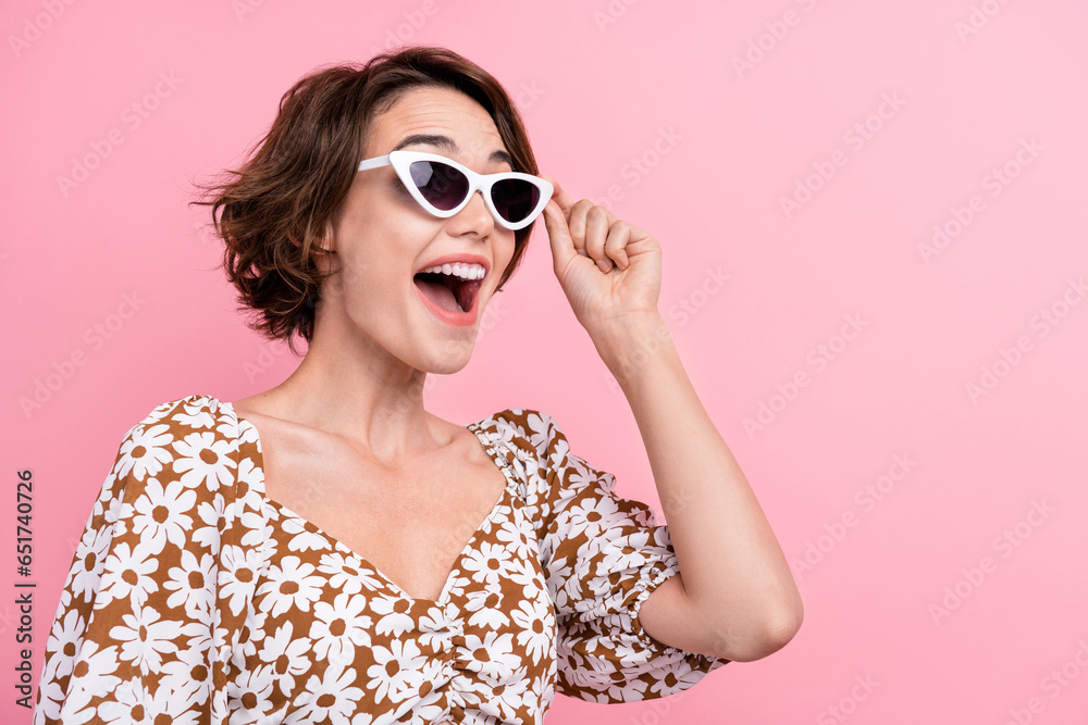 Profile portrait of astonished positive girl hand touch sunglass empty space ad isolated on pink color background