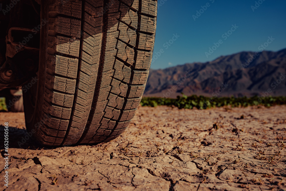 Car wheel on cracked ground in desert