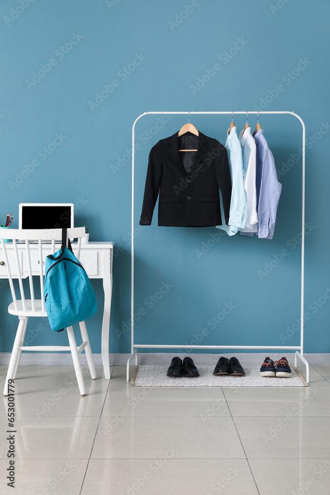 Stylish interior of modern childrens room with school uniform and shoes