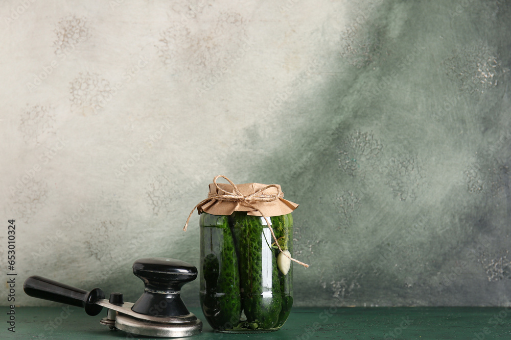 Jar with canned cucumbers on table