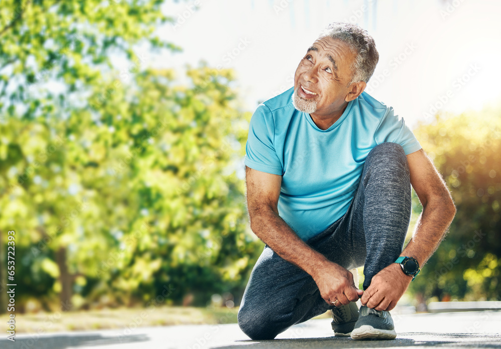 Tying laces, man and in a park for running, exercise and getting ready for outdoor cardio. Smile, idea and a mature or senior male athlete with shoes in the street for a workout, exercise or training