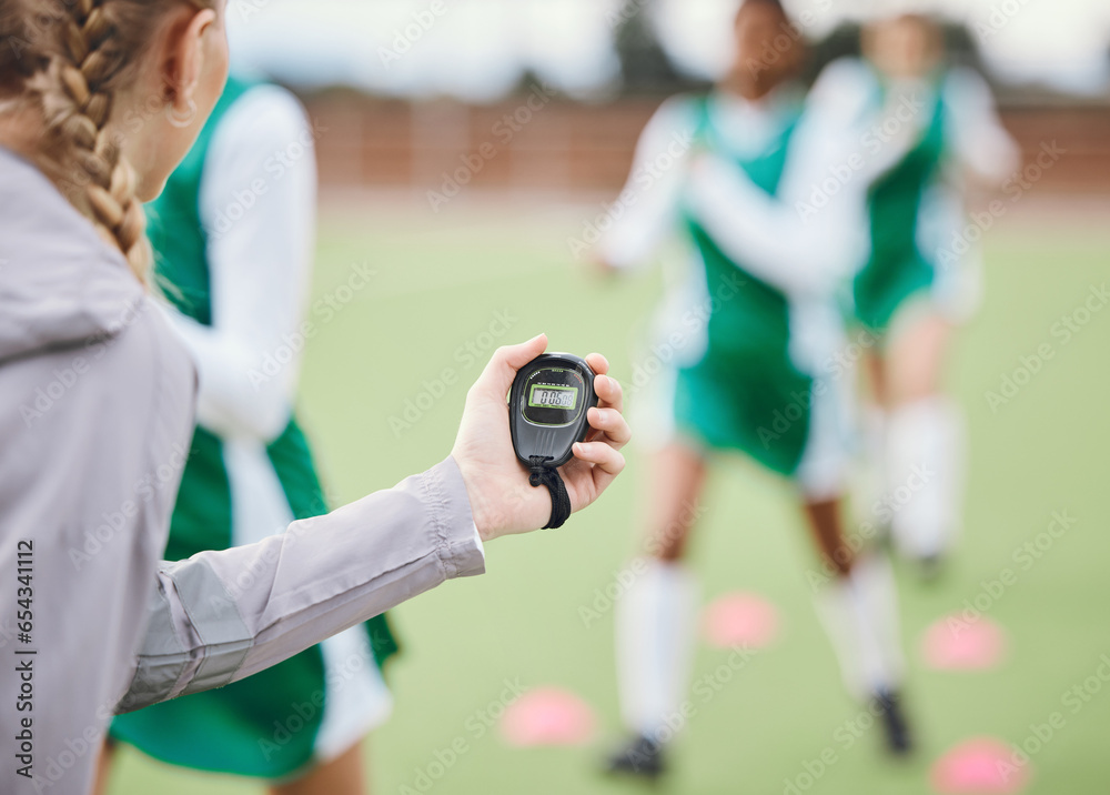 Coach, timer and team in training, field and sports in blurred background. Trainer, stopwatch and teaching for progress, fitness and performance by digital, athlete and exercise in diversity on clock
