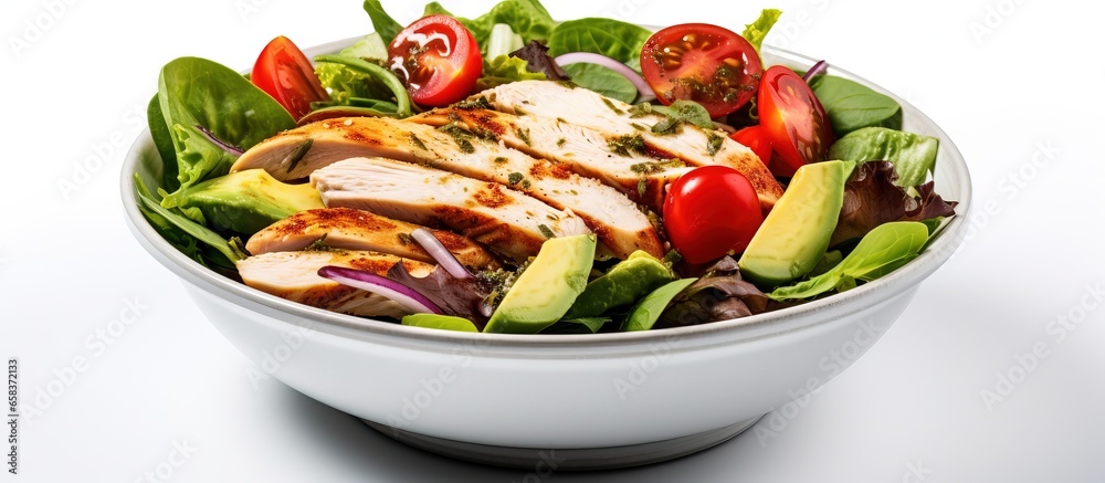 Close up of a healthy chicken salad with tomatoes spinach and avocado on a white background