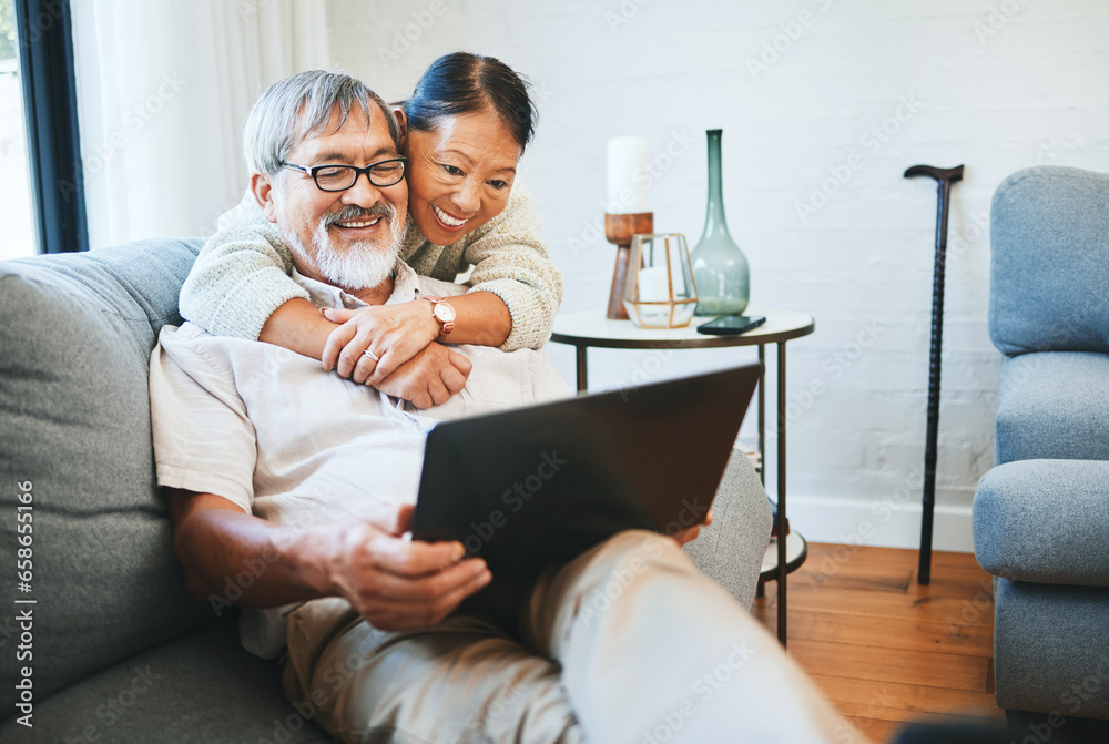 Laptop, happy and senior couple on a sofa watching movie, show or film together in living room. Smile, technology and elderly man and woman in retirement streaming a video on computer at modern home.