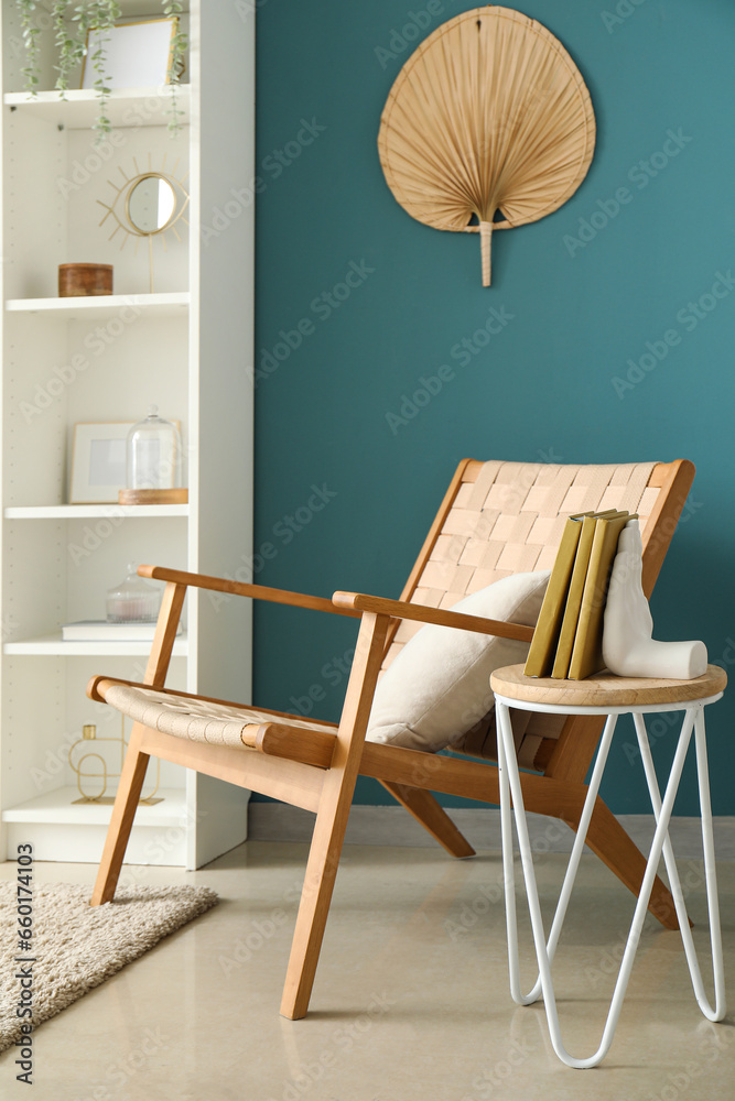 Chair with stylish holder for books on table in room