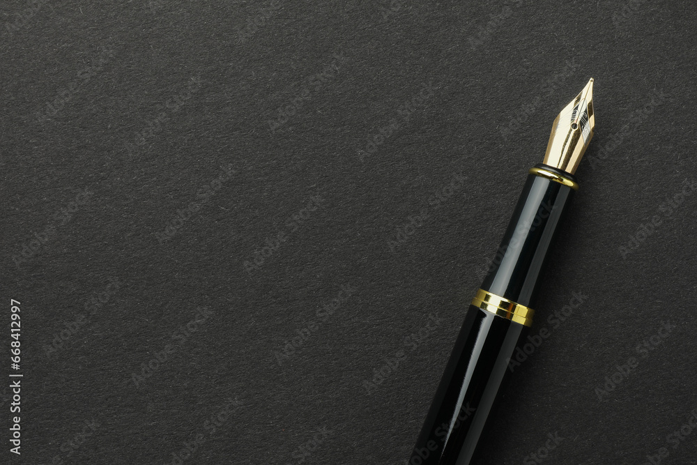 Stylish fountain pen on black background, top view. Space for text