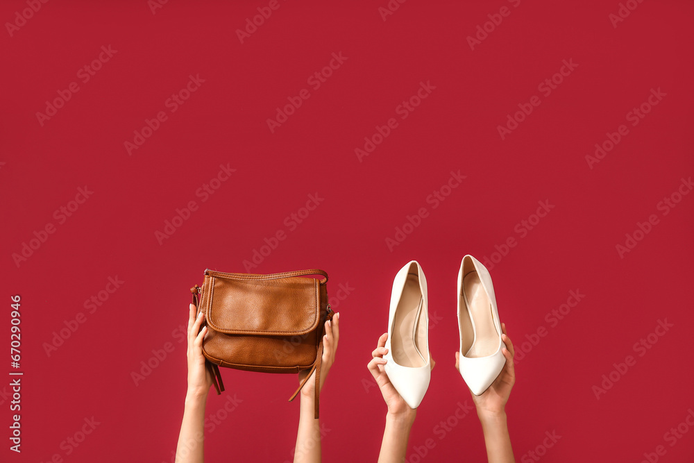 Female hands with stylish purse and shoes on red background. Black Friday sale