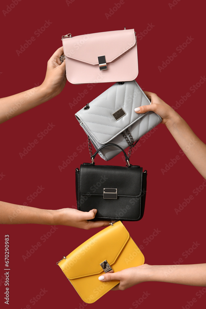 Female hands with stylish purses on red background. Black Friday sale
