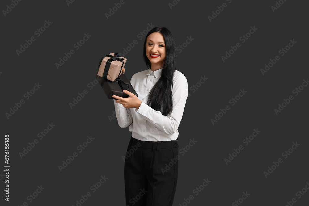 Beautiful stylish woman with gift boxes on dark background. Black Friday Sale
