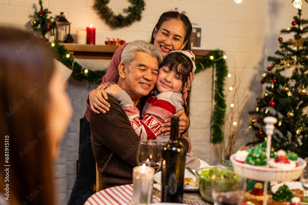 Asian kid hugging grandparent while celebrate Christmas party in house. 
